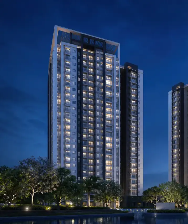 A residential tower lit at twilight above a row of trees