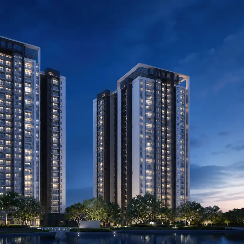 The two towers lit at twilight above a landscaped edge